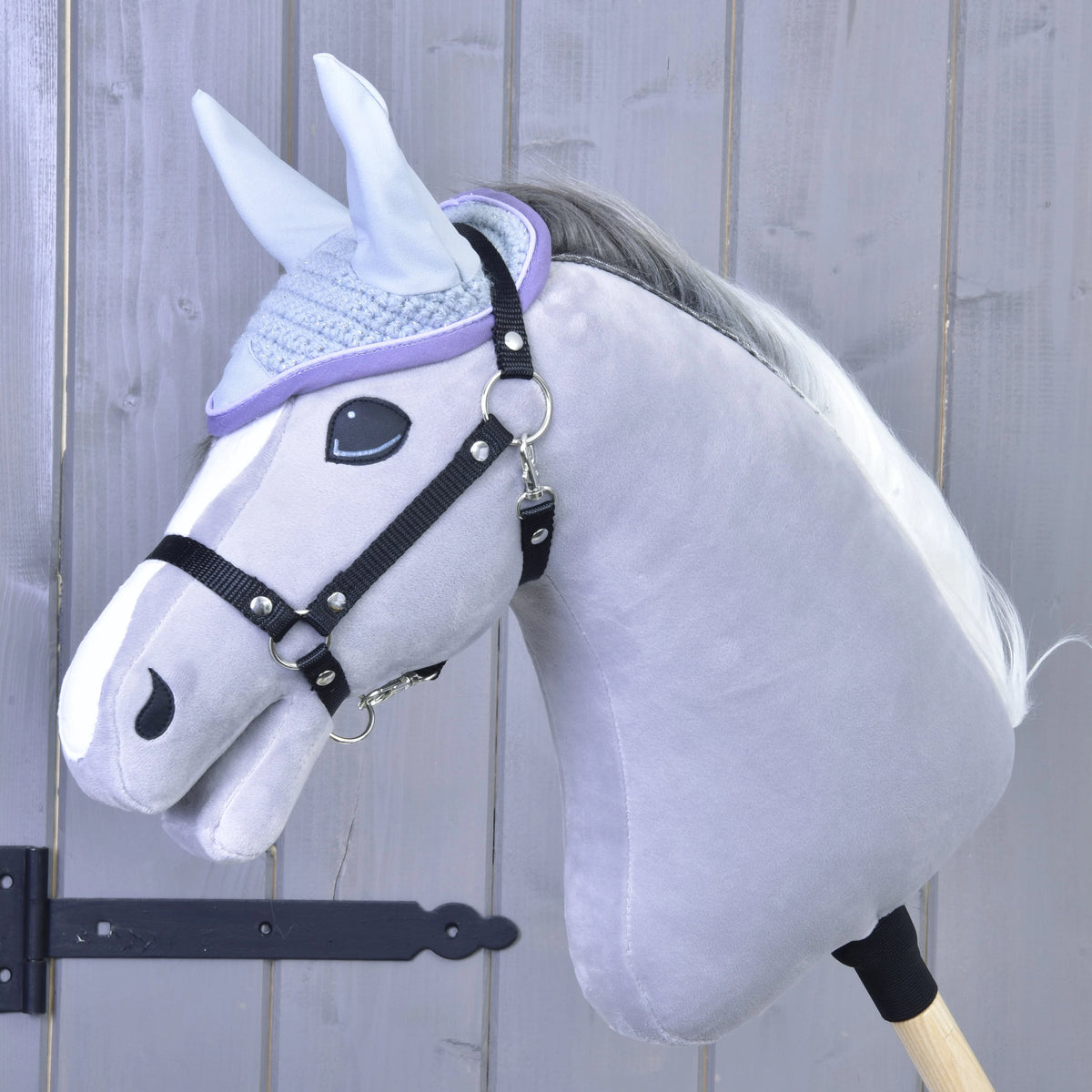 Hobby Horse gris clair à crinière grise et blanche avec licol noir portant le bonnet d’oreilles gris pâle au crochet