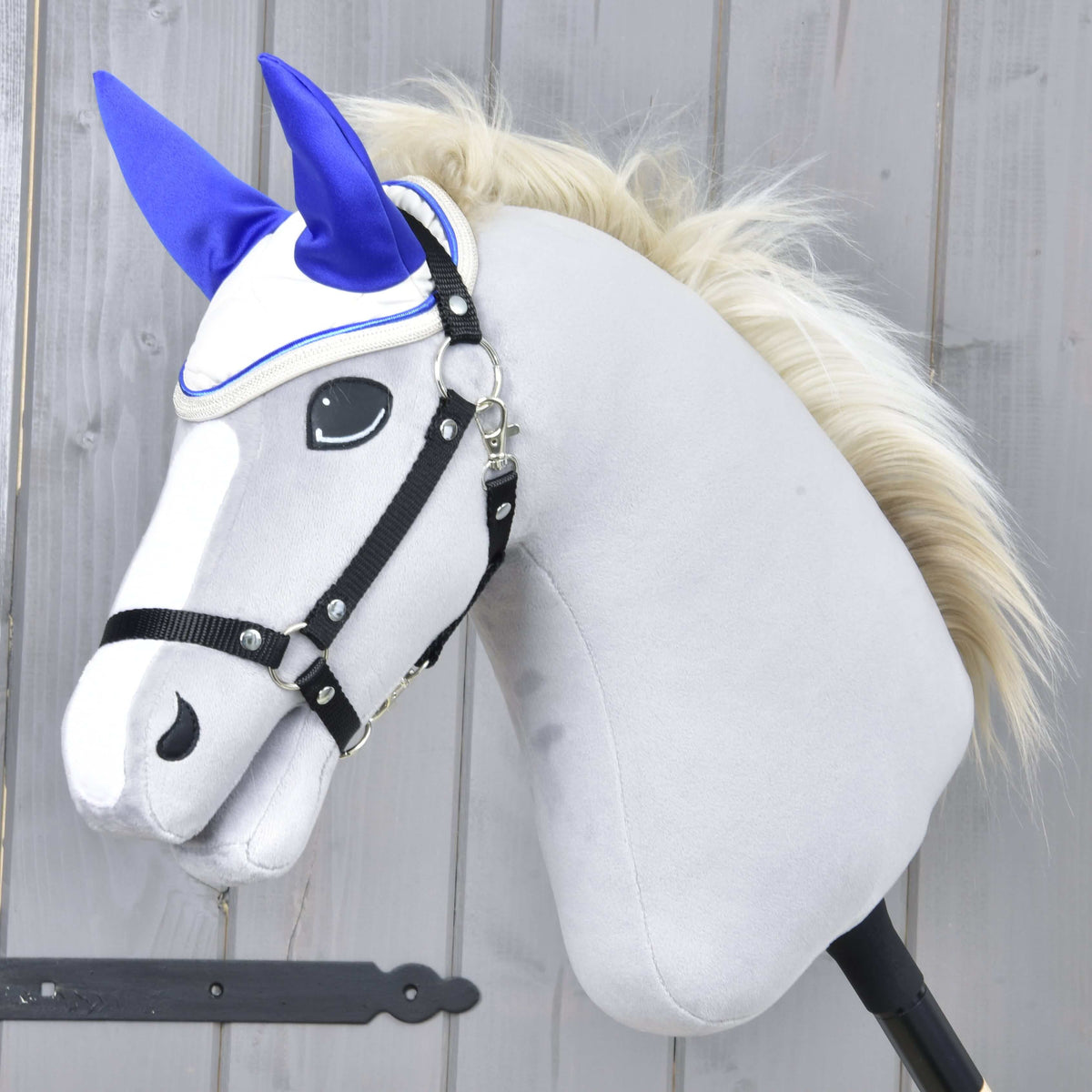 Hobby Horse gris à crinière blonde et licol noir portant le bonnet d’oreilles Cream Pearl aux oreilles bleu roi vif
