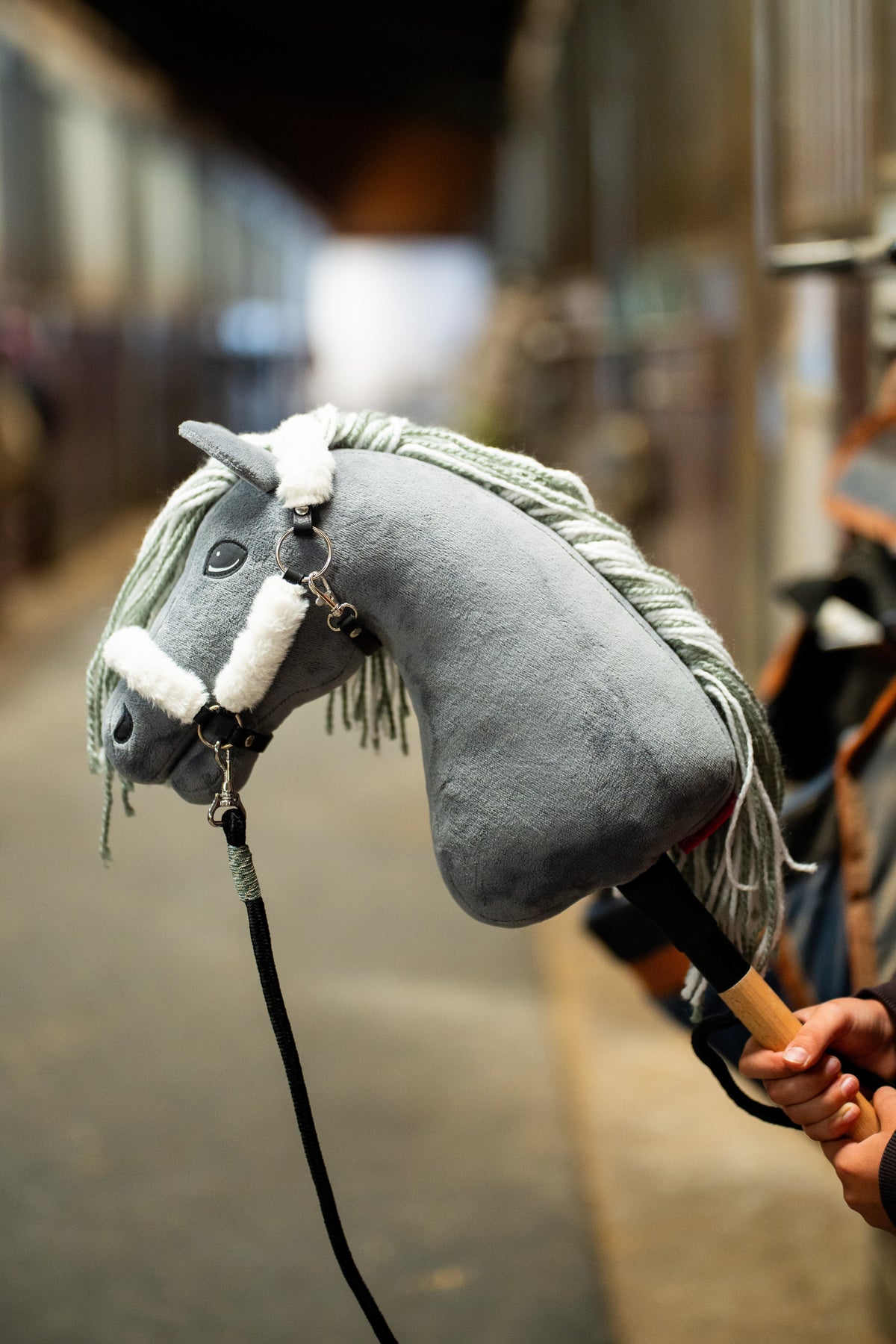 Close-up of Hobby Horse Calypso in the white fur halter, fluffy fur on noseband and crownpiece and a black lead rope