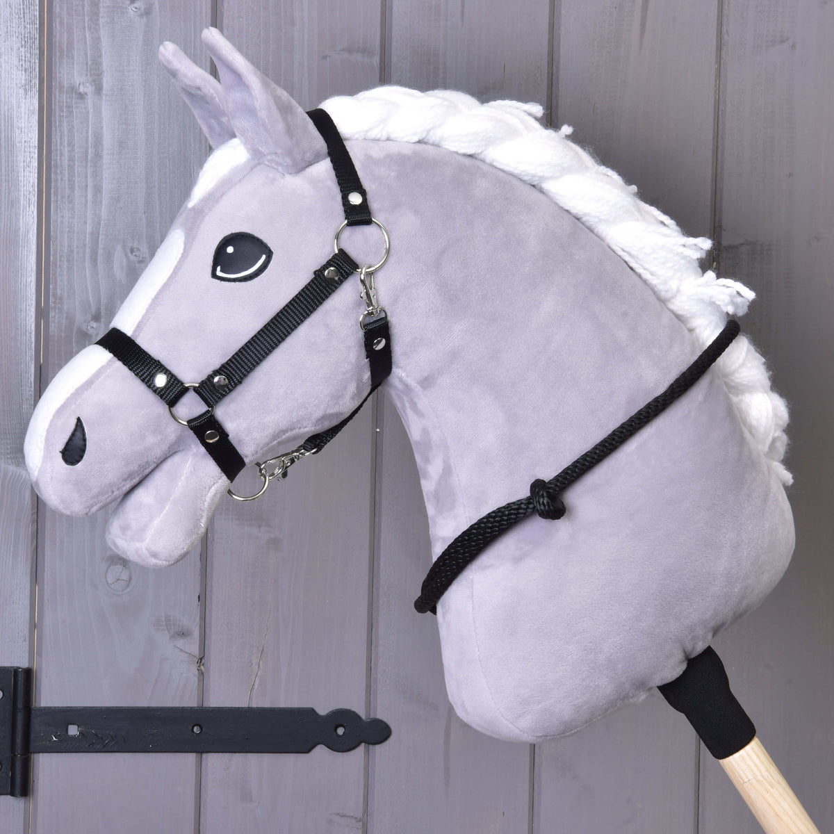 Grijze Hobby Horse met zwart halster van singelband en de zwarte touwen cordeo om de hals