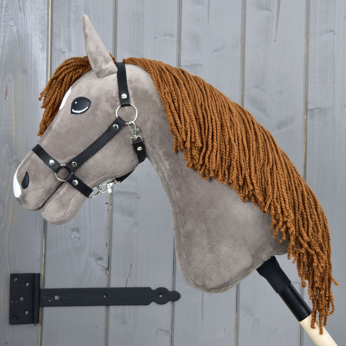 Hobby Horse Chanell de profil gauche, sa longue crinière rousse en fil tombant le long de l’encolure gris-brun