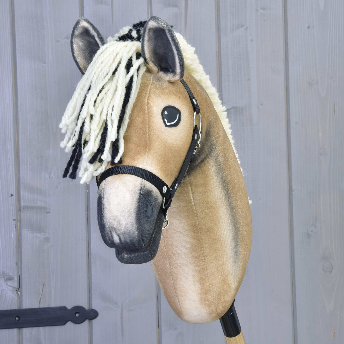 Front view of Hobby Horse Colby with a cream and black yarn forelock, dark ear tips and a black halter