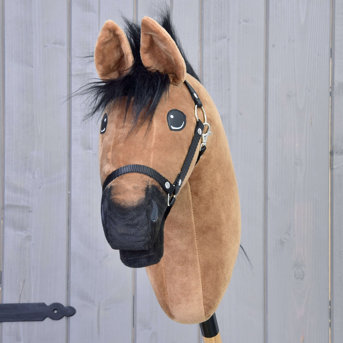 Lichtbruine Hobby Horse van voren met zwarte kuif van bont, zwarte neus en zwart halster