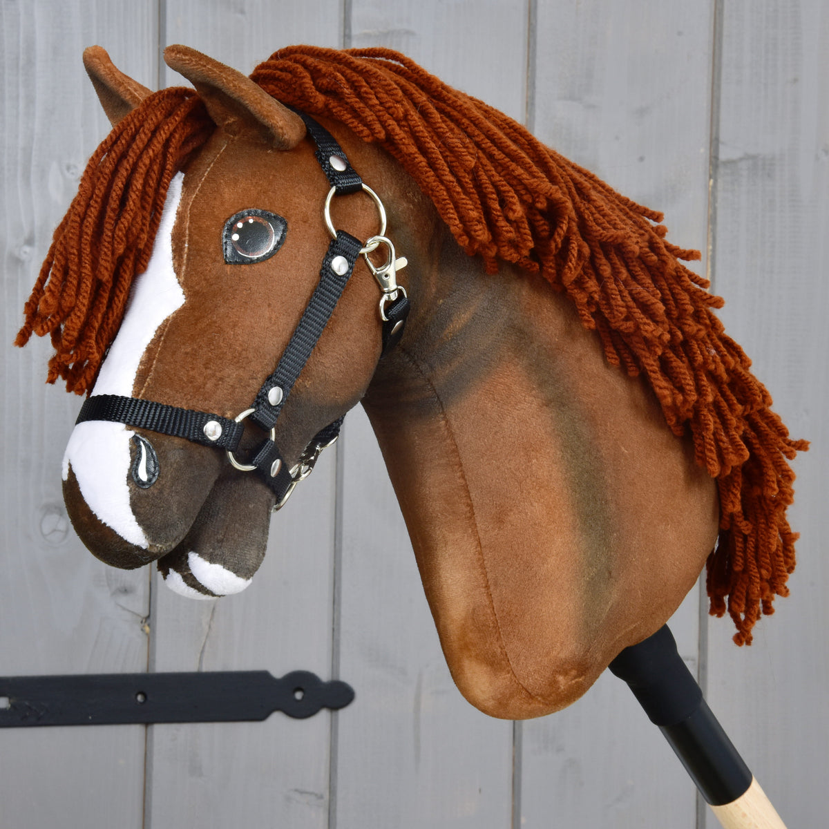 Hobby Horse Cooper avec licol noir de LarDen, tête en peluche brun alezan avec liste blanche et crinière en fil cuivré