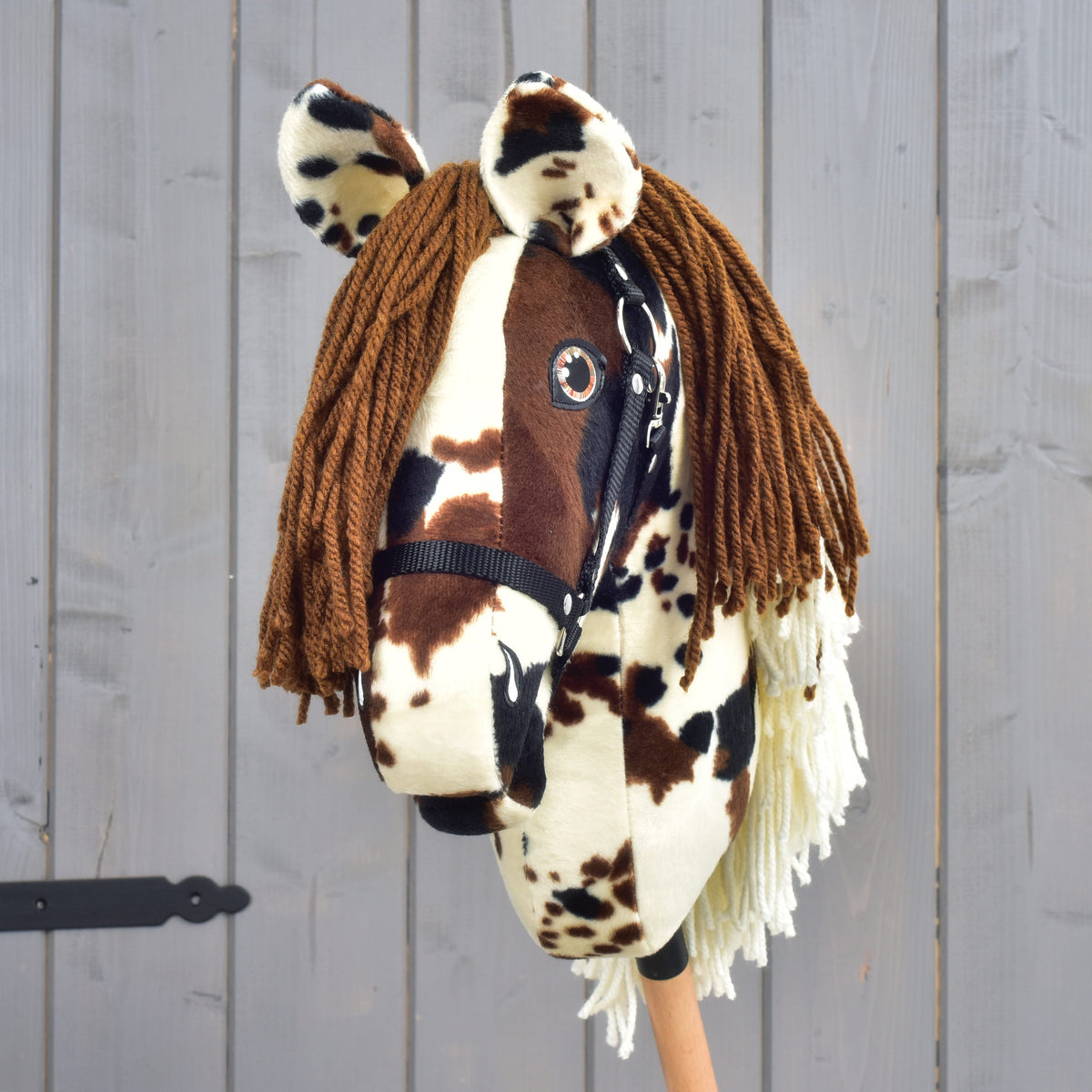 Hobby Horse Dakota avec licol noir de face, toupet en fil brun et oreilles tachetées au-dessus des yeux ambrés