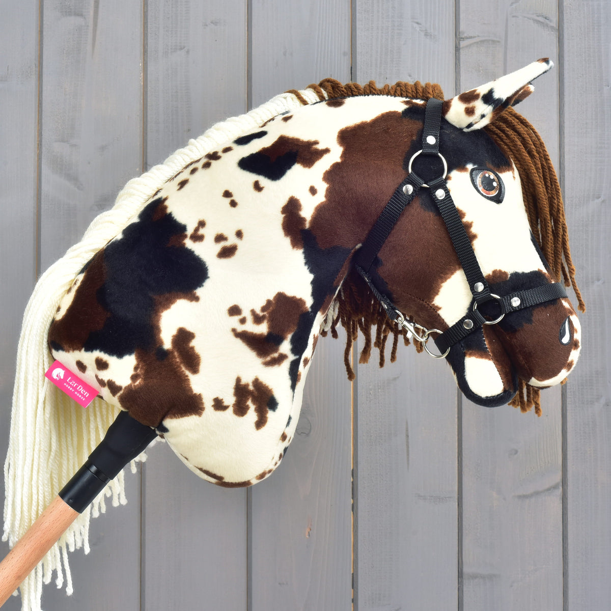 Hobby Horse Dakota avec licol noir vu de droite, étiquette rose LarDen sur l’encolure tachetée et crinière crème