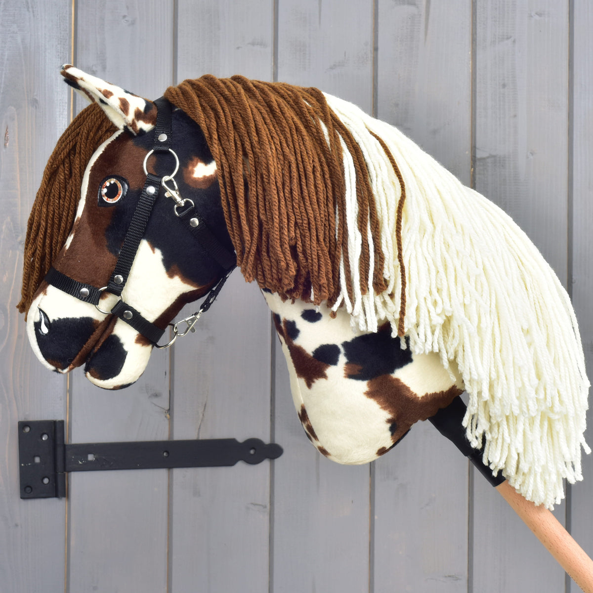 Hobby Horse Dakota avec licol noir vu de gauche, crinière bicolore en fil brun et crème sur l’encolure
