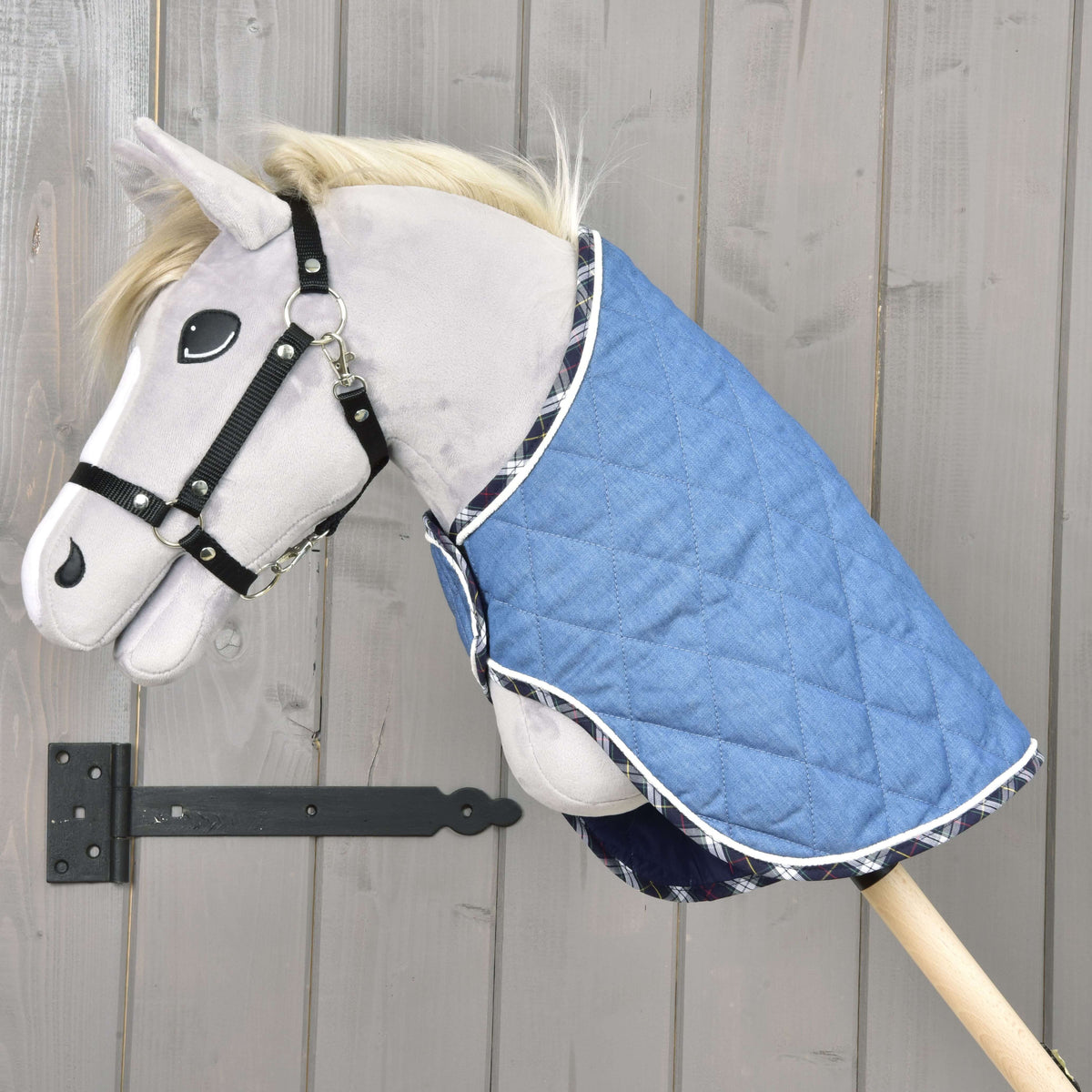 Hobby Horse gris avec licol noir portant la couverture matelassée Beautiful Jeans à bordure écossaise sur l’encolure