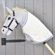 Grijze Hobby Horse met zwart halster draagt de Deken Cream Pearl, crème gewatteerd met koningsblauwe bies, over de hals