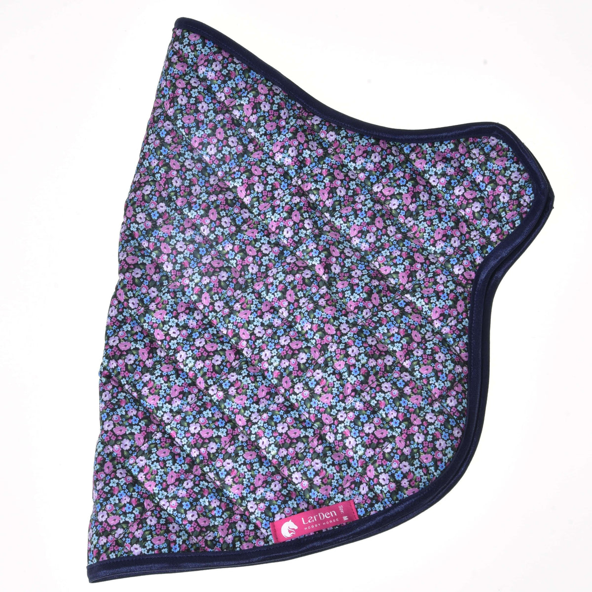 Couverture fleurie matelassée posée à plat de côté, petites fleurs roses, lilas et bleues, bordure bleu marine et étiquette LarDen rose