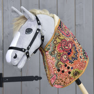 Hobby Horse en peluche grise avec licol noir portant la couverture colorée à spirales roses, vertes et marine