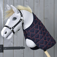 Hobby Horse gris à crinière blonde et licol noir portant la couverture Pink Heart bleu marine sur l’encolure
