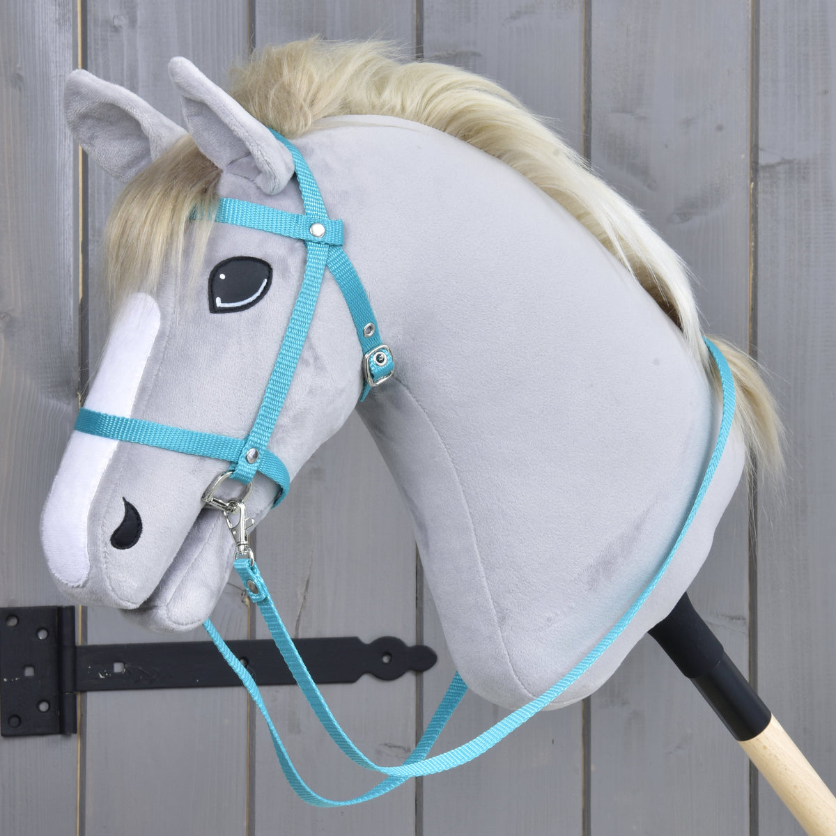 Hoofdstel met teugels van band turquoise van LarDen voor Hobby Horse op een lichtgrijs pluche hoofd met blonde manen