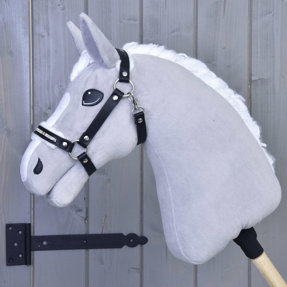 Light grey Hobby Horse with white mane wearing the black leatherette halter with white fur and rhinestones