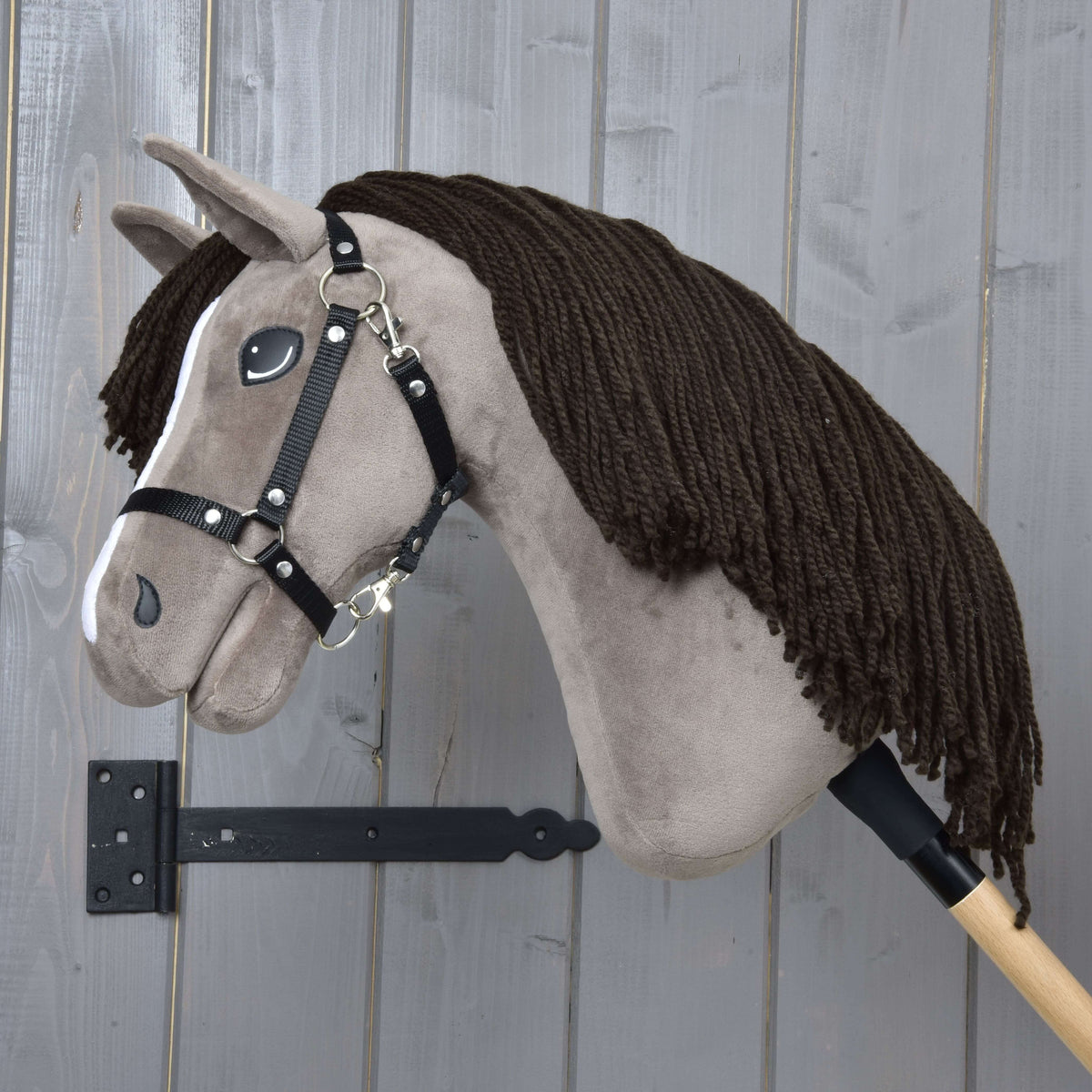 Hobby Horse Guccini de profil gauche, sa longue crinière brun foncé en fil sur l’encolure, licol noir