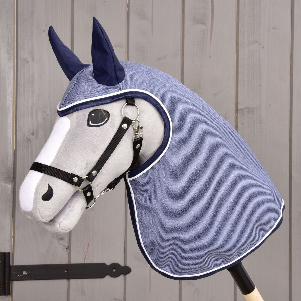 Hobby Horse gris clair avec licol noir portant l’imperméable Jeans, tissu bleu denim, oreilles bleu marine et passepoil blanc