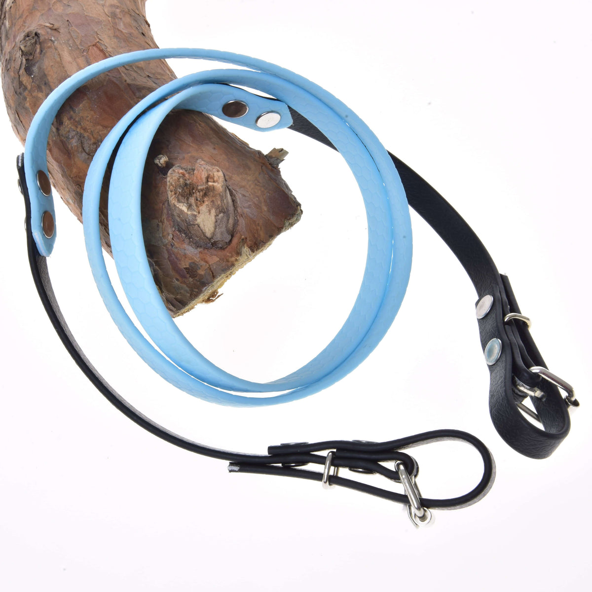 Teugels gerubberd Light blue van LarDen voor Hobby Horse, lichtblauw midden en zwarte uiteinden met gespen, over een dennentak