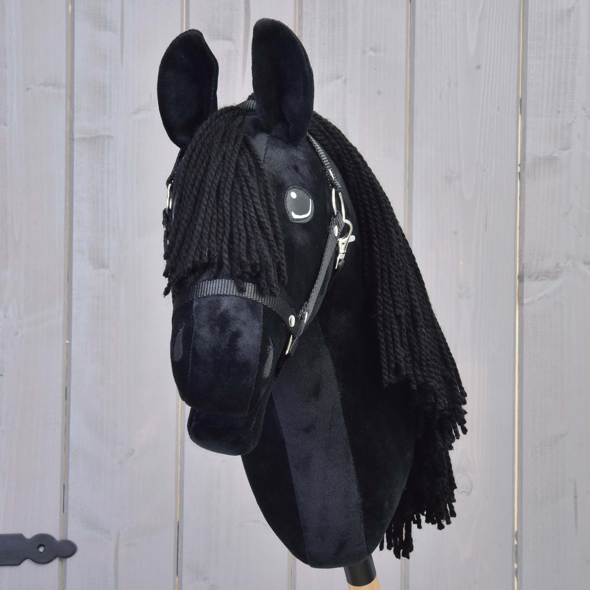 Hobby Horse Mahal met zwart halster van voren, zwarte lok van garen tussen de rechtopstaande zwarte pluche oren