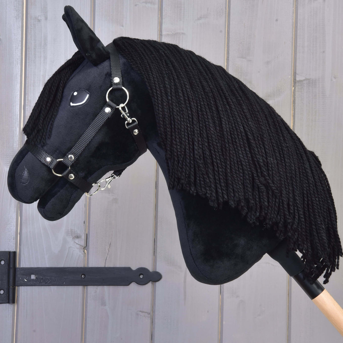 Hobby Horse Mahal met zwart halster met gebogen hoofd, dikke zwarte manen van garen over de zwarte pluche hals