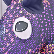 Close-up of the eye opening in the purple and black Mandala suit with pink, yellow and violet diamond motifs on a Hobby Horse