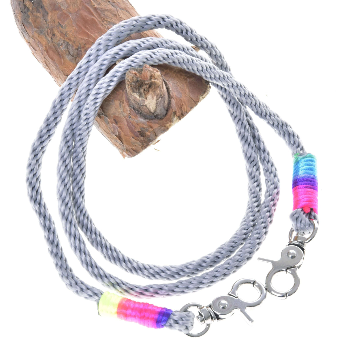 Hobby Horse Reins Manhattan by LarDen, grey rope reins with rainbow wrapped ends and silver snap hooks, on a branch