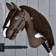 Hobby Horse Monte met zwart halster van LarDen, donkerbruin pluche met witte bles en vlekken en lange bruine manen van garen