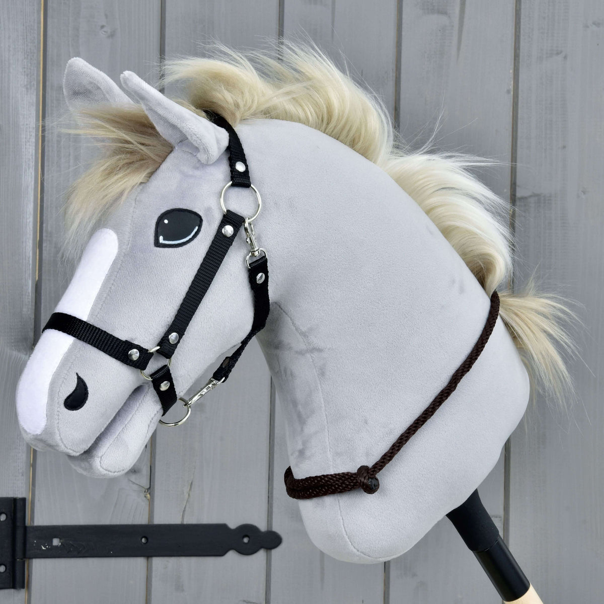 Lichtgrijze Hobby Horse met crème manen, zwart halster en de Cordeo Chocolate laag om de hals