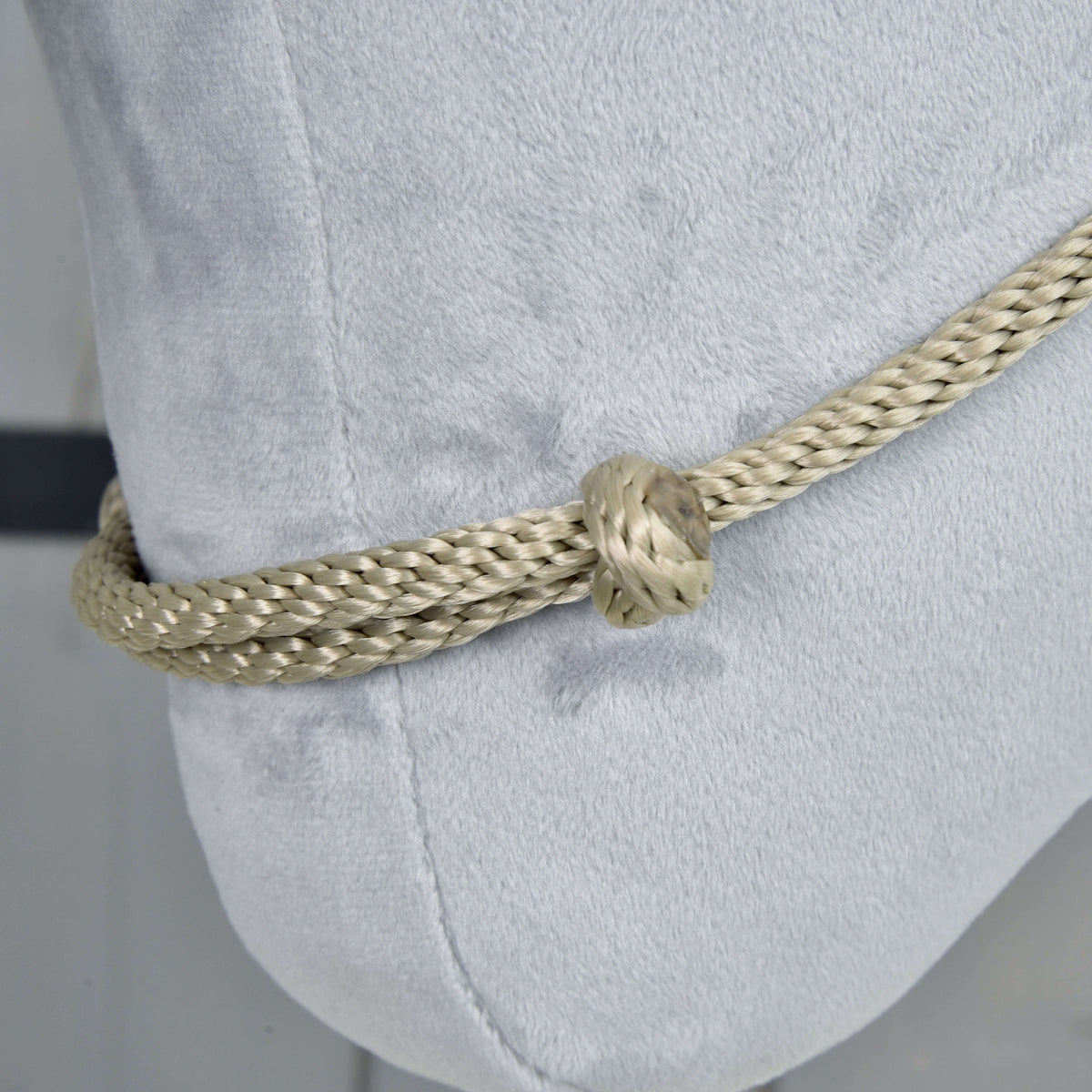 Gros plan sur le cordéo Eleganza sur peluche gris clair : corde tressée beige grisé passée en double dans un nœud rond