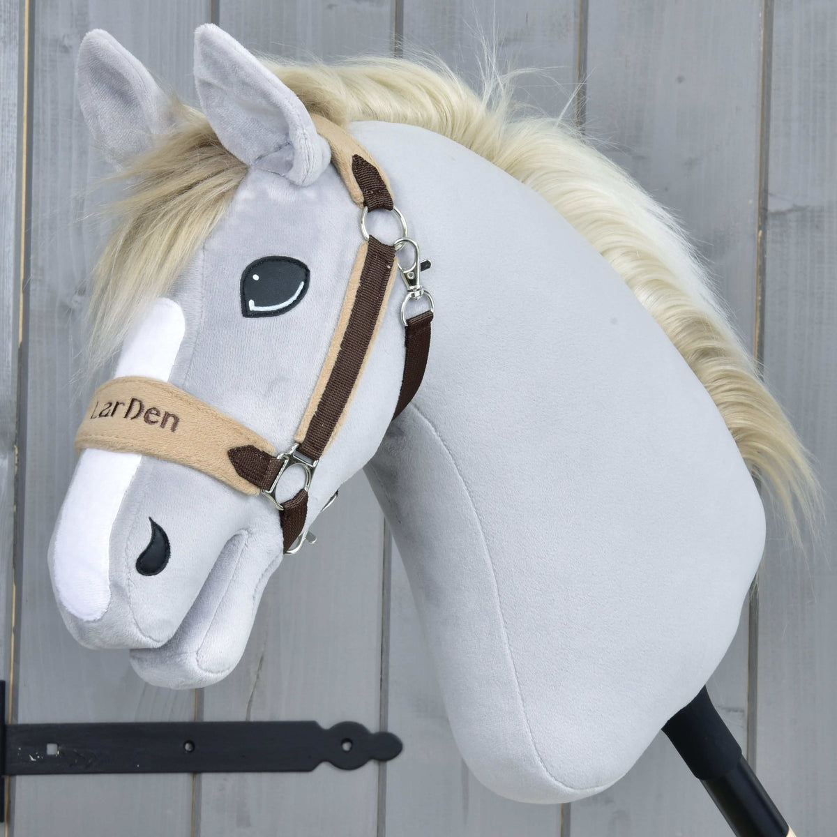 Grijze pluche Hobby Horse met crèmekleurige manen in de bruine halster met bont, LarDen geborduurd op de beige neusriem