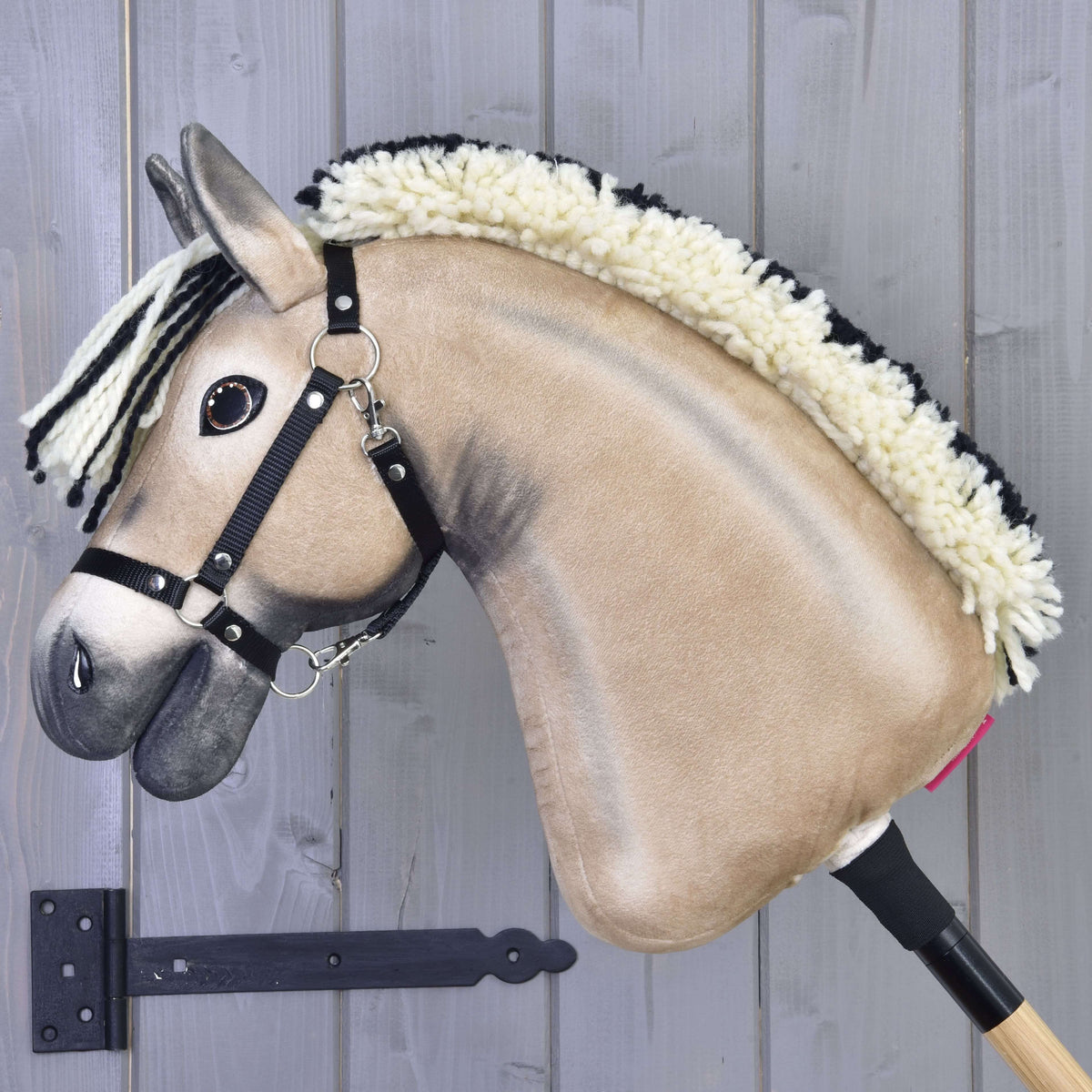 Hobby Horse Ozzy in left profile with a dark dorsal stripe, upright cream mane edged in black and a black halter