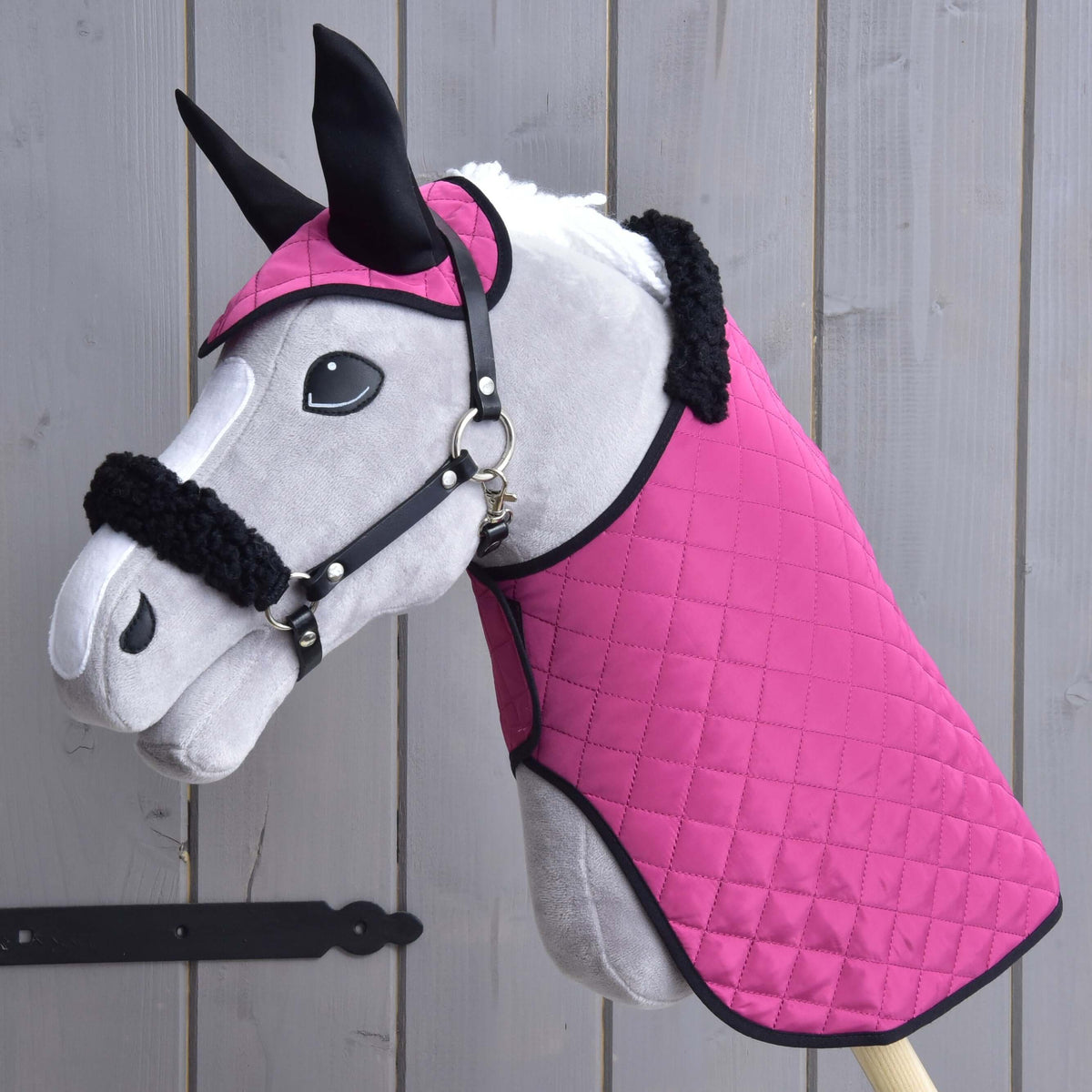 Hobby Horse gris portant l’ensemble Pink Beauty : couverture et bonnet d’oreilles roses matelassés, oreilles noires, licol noir avec fourrure