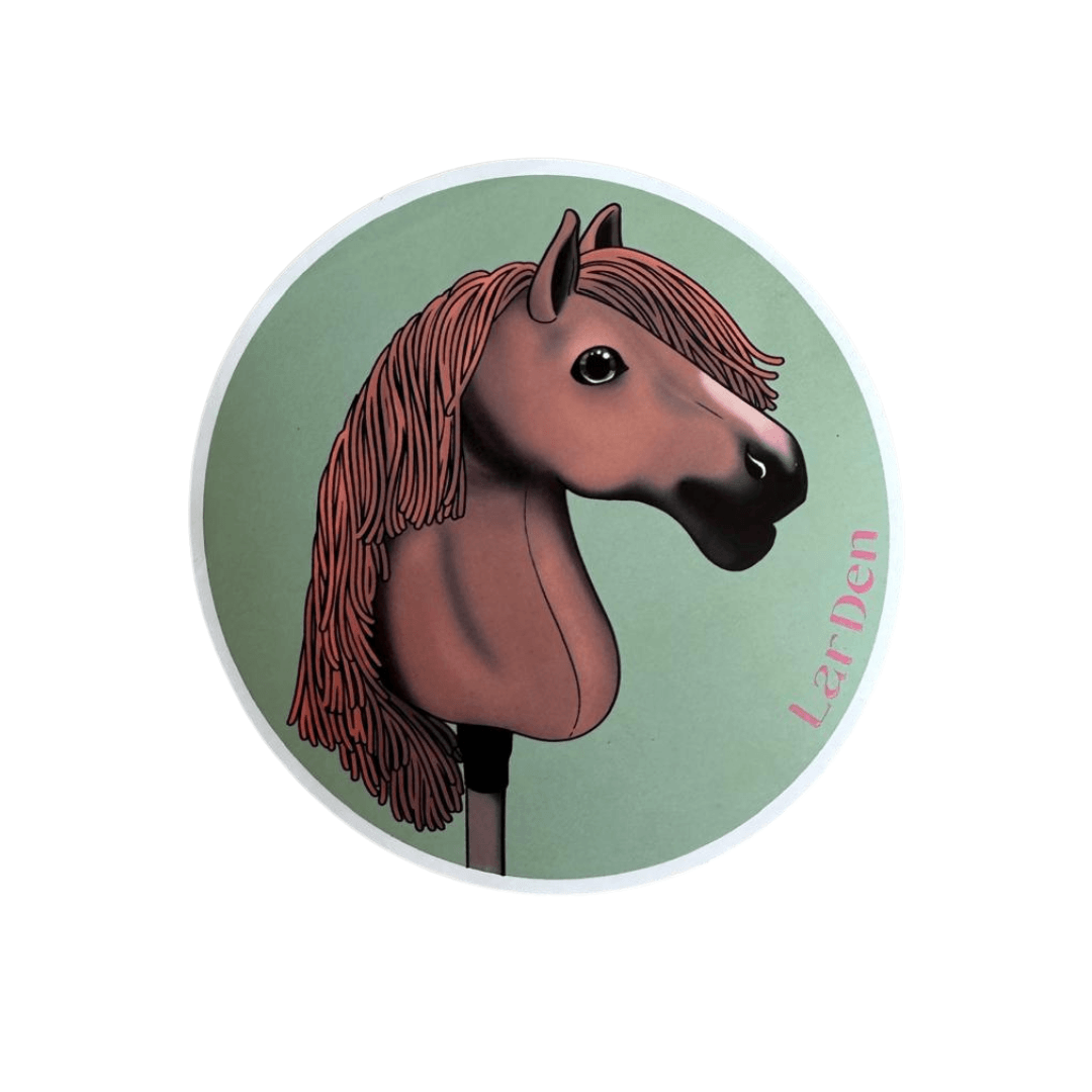 Sticker met een voskleurige Hobby Horse met lange roodachtige manen en donkere neus op een saliegroene cirkel, LarDen in roze