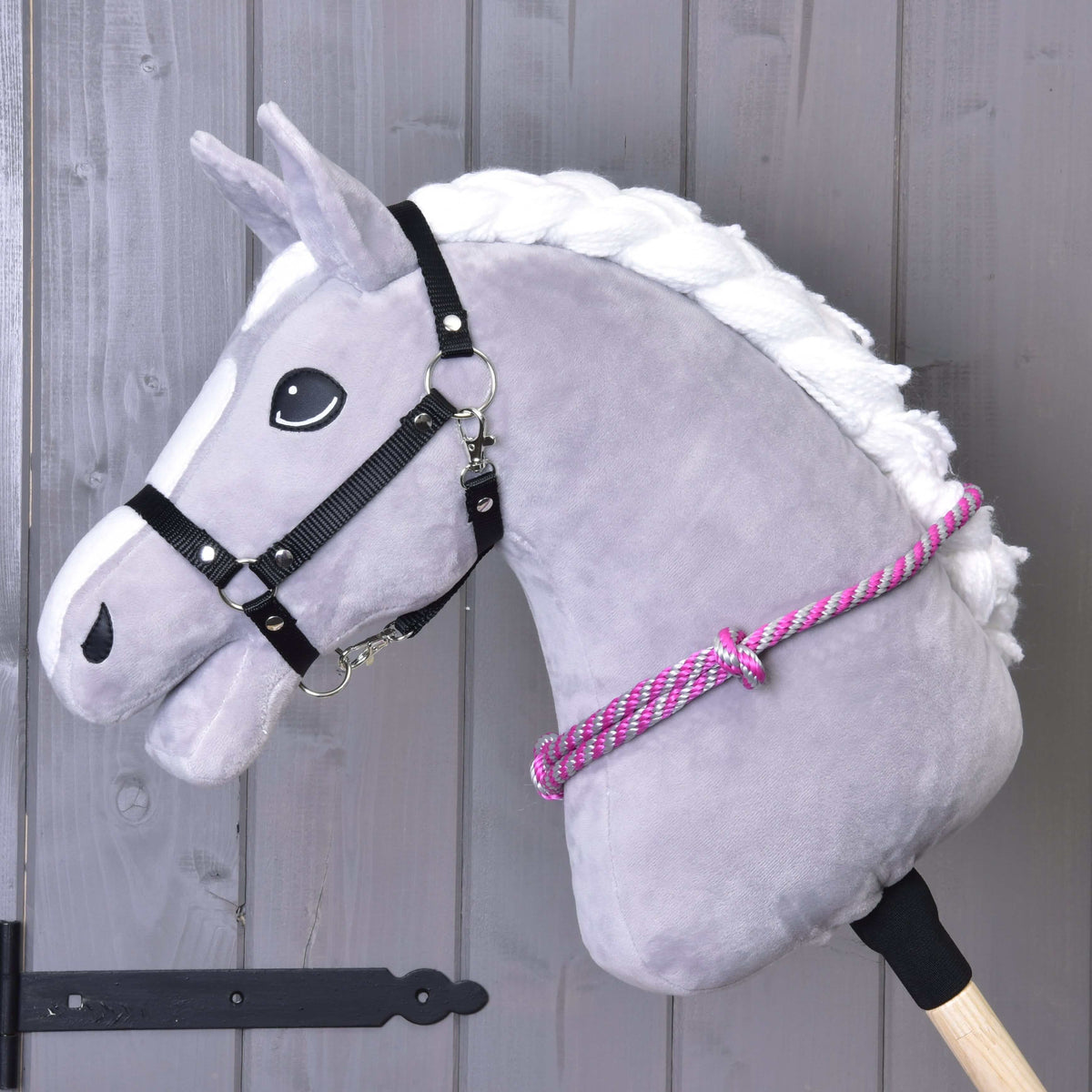 Grijze Hobby Horse met zwart halster en de roze-grijs gestreepte touwen cordeo om de hals