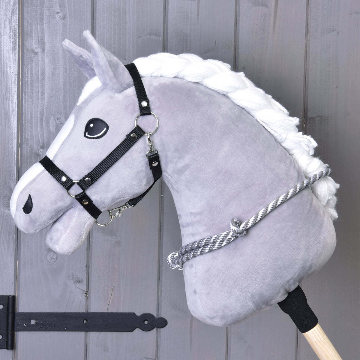 Grijze Hobby Horse met zwart halster en de grijs-wit gestreepte touwen cordeo om de hals