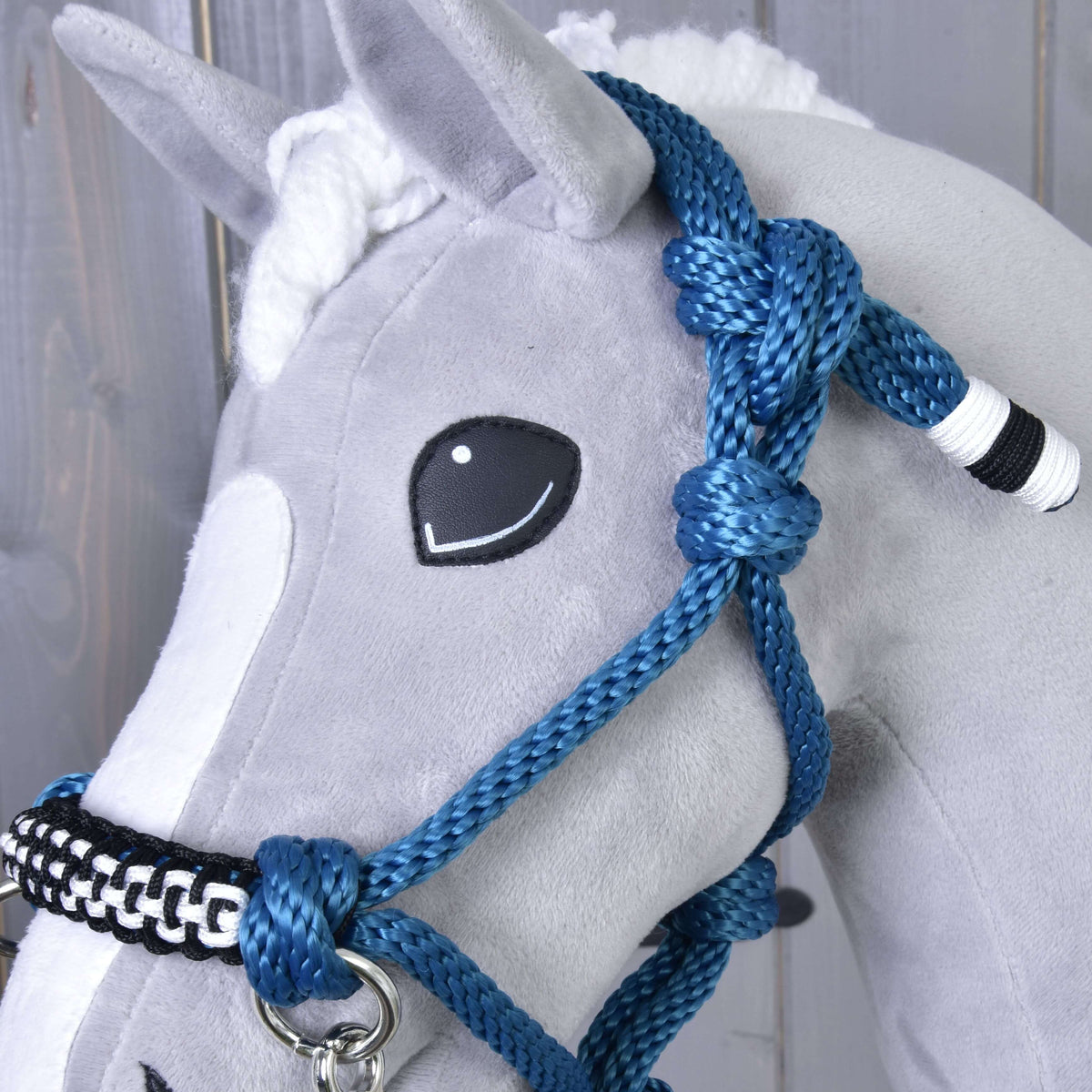 Gros plan sur les nœuds du licol en corde bleu de l’ensemble de corde Chess pour Hobby Horse, extrémité enroulée noir et blanc