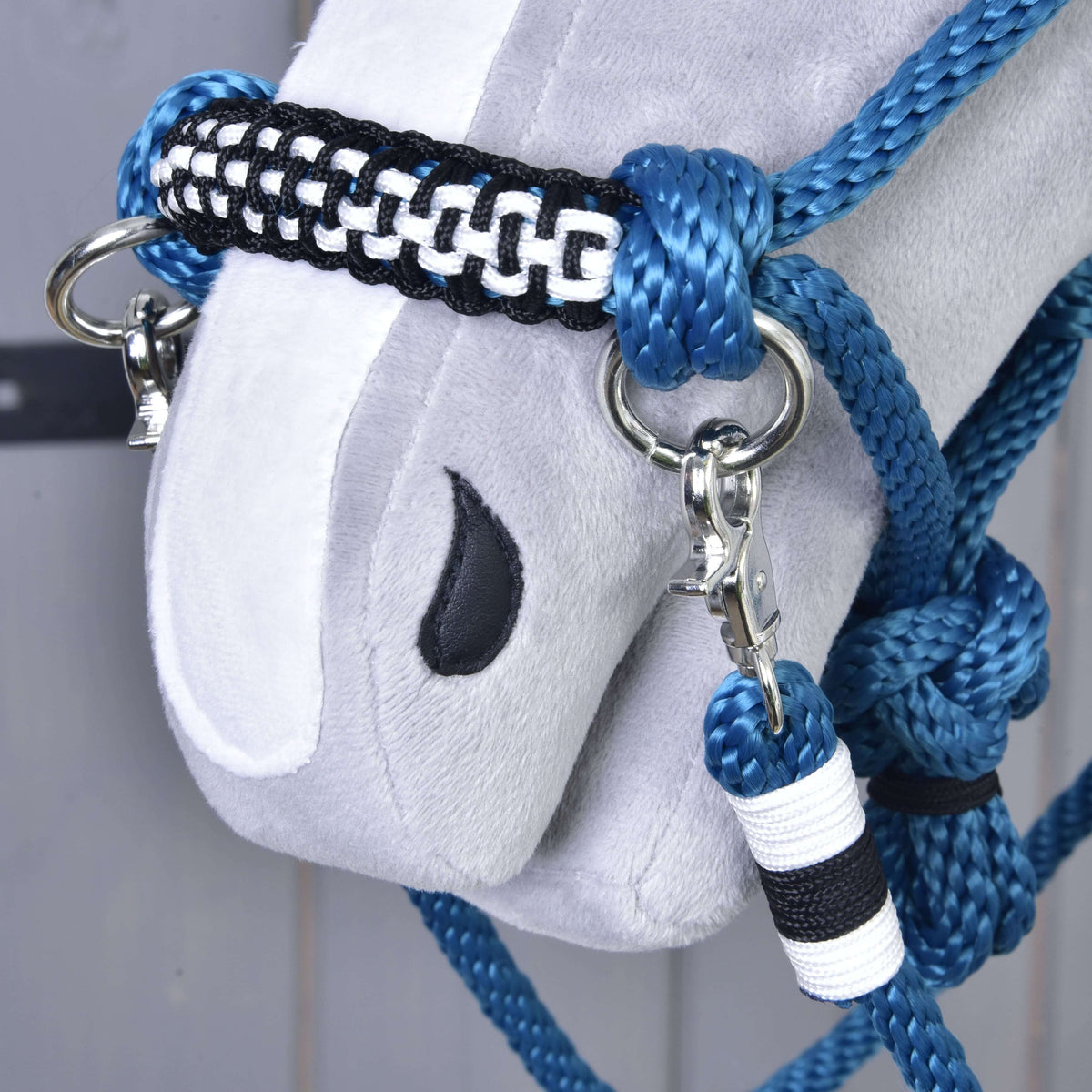 Gros plan sur l’ensemble de corde Chess pour Hobby Horse, muserolle tressée noire et blanche à anneaux argentés et mousqueton