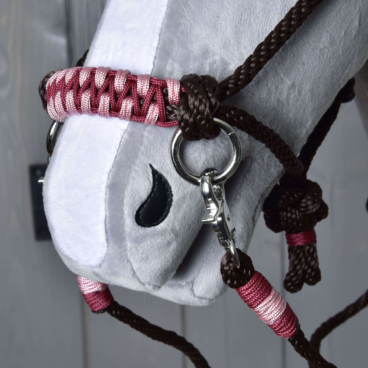 Close-up van de neusriem van de Touwset York, bordeauxrood en roze gevlochten, met zilverkleurige ring, karabijnhaak en donkerbruin touw