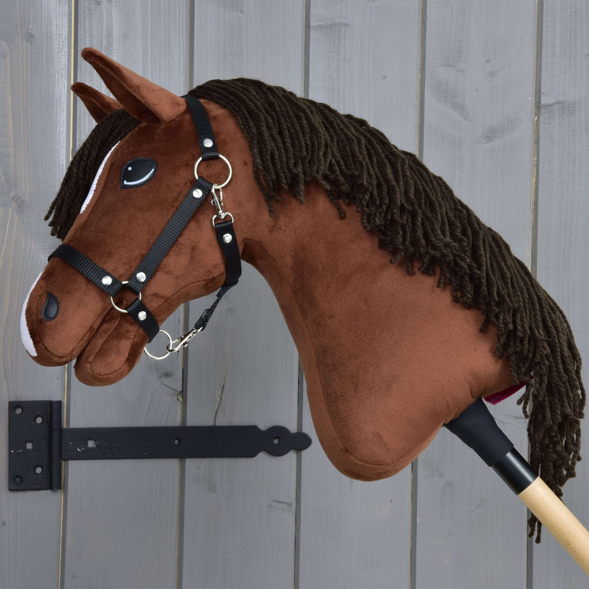 Hobby Horse Rocky in left profile with the long dark brown yarn mane over the chestnut neck and a black halter