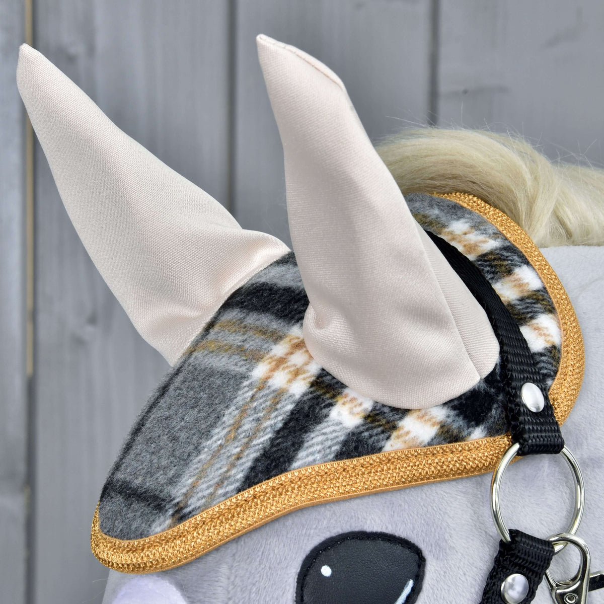 Close-up van het oornetje uit de Set England Grey: crème oren, grijs-zwarte ruit en goudbruine gevlochten rand