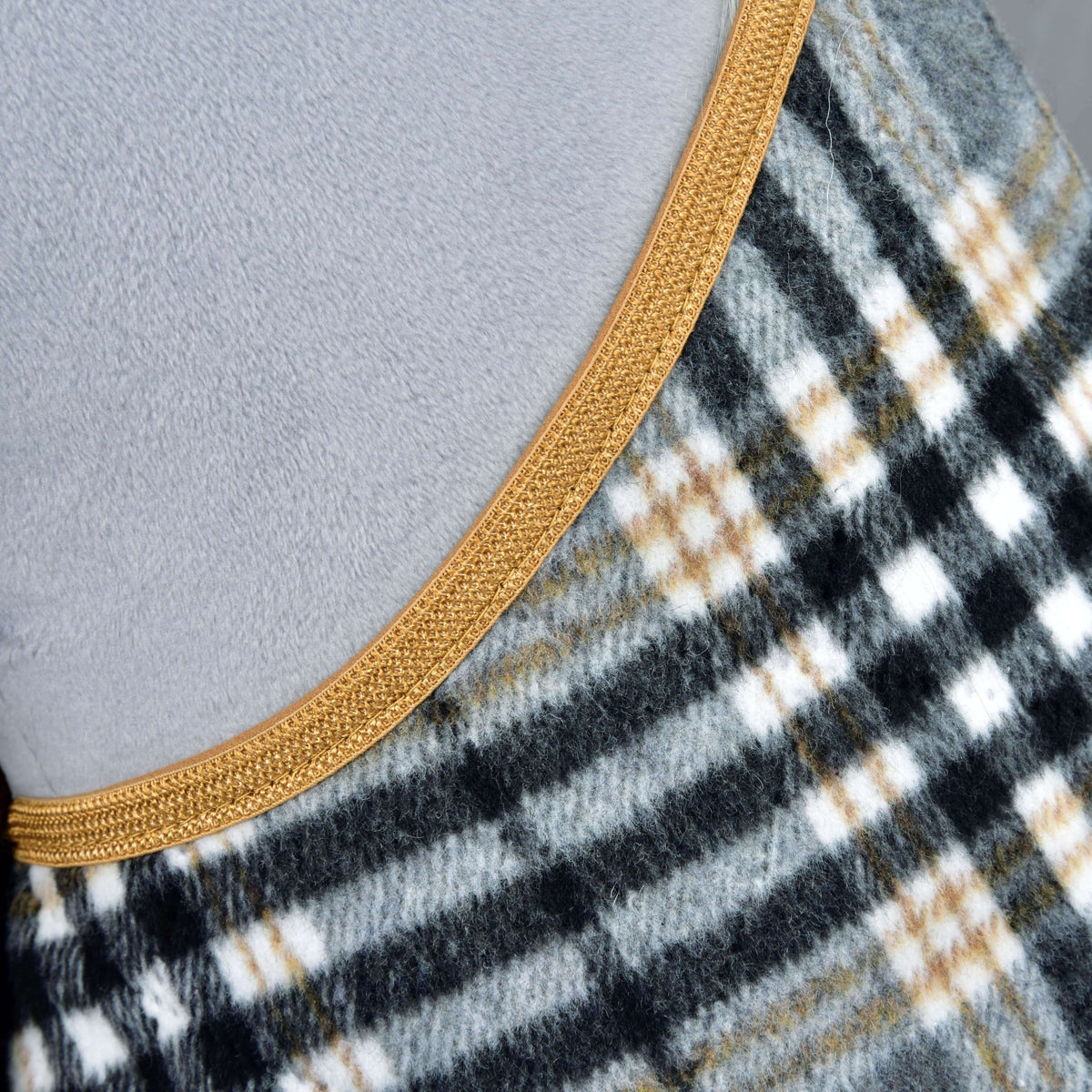 Close-up van de deken uit de Set England Grey: zachte grijs-zwart-witte ruit met camel lijnen en goudbruine rand