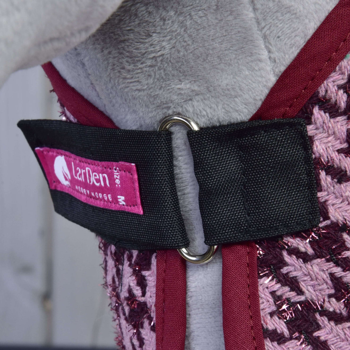 Borstsluiting van de deken uit Set Harmony Elsa: zwarte riem, metalen ring, roze LarDen-label en bordeaux bies
