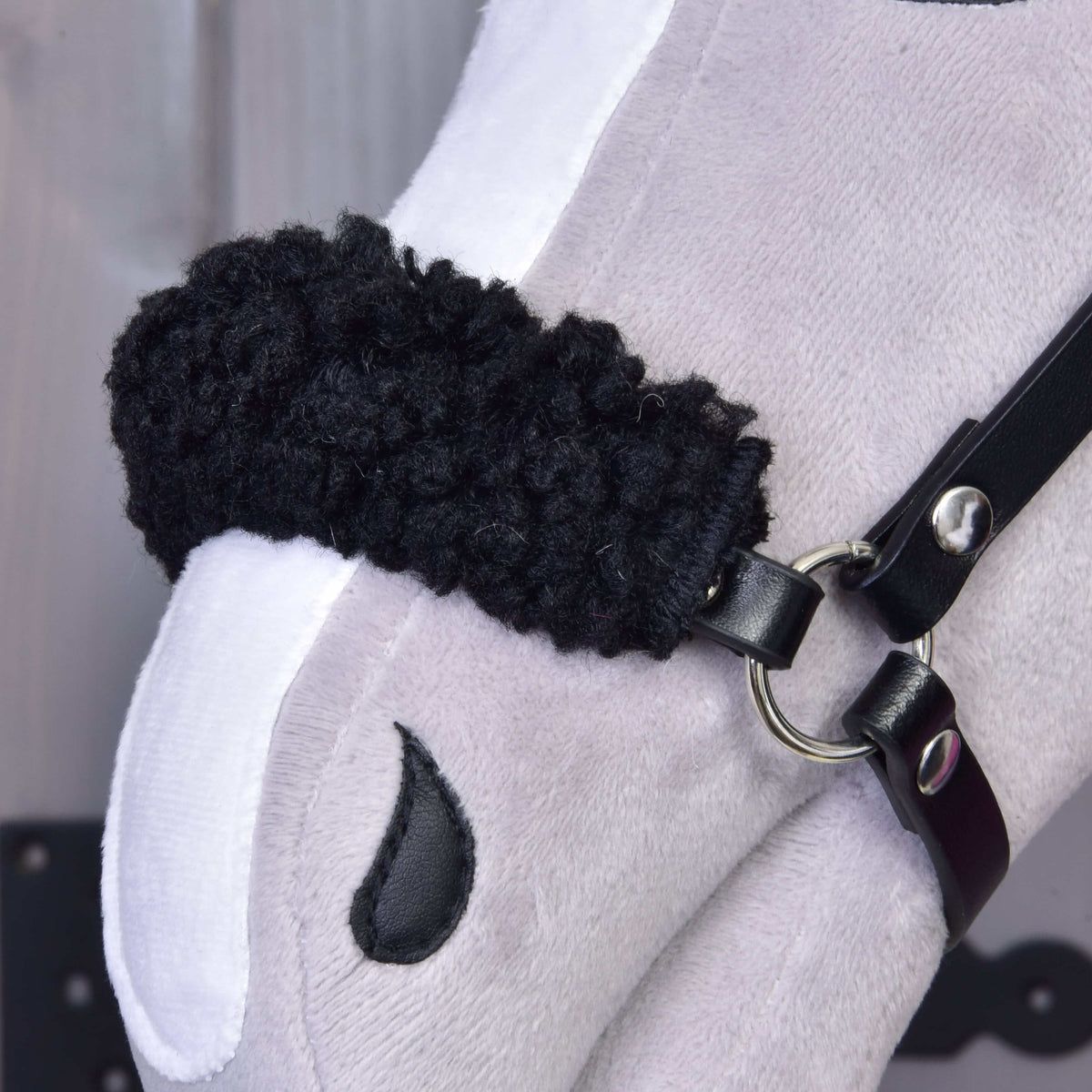 Close-up van de vulling van zwart krullend fleece op de neusriem van de halster uit Set Harmony Pink op een Hobby Horse