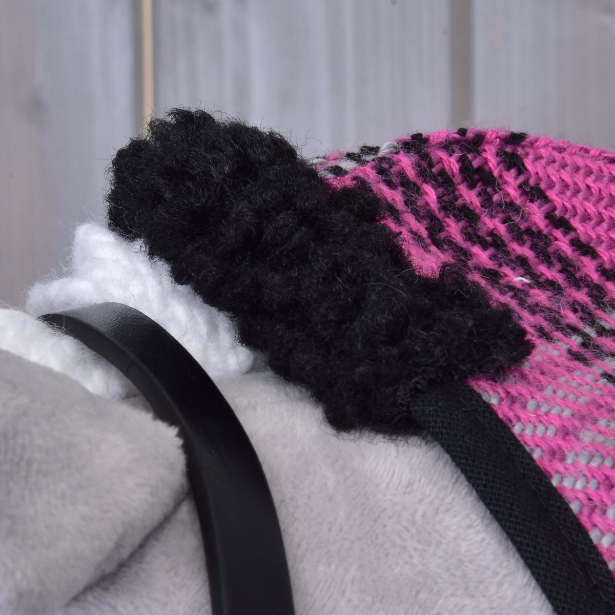 Close-up van de zwarte krullende fleecekraag op de roze-zwart geruite deken van Set Harmony Pink op een Hobby Horse