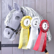 Hobby Horse gris en peluche à crinière en fil gris et blanc portant les trois cocardes numérotées à l’encolure
