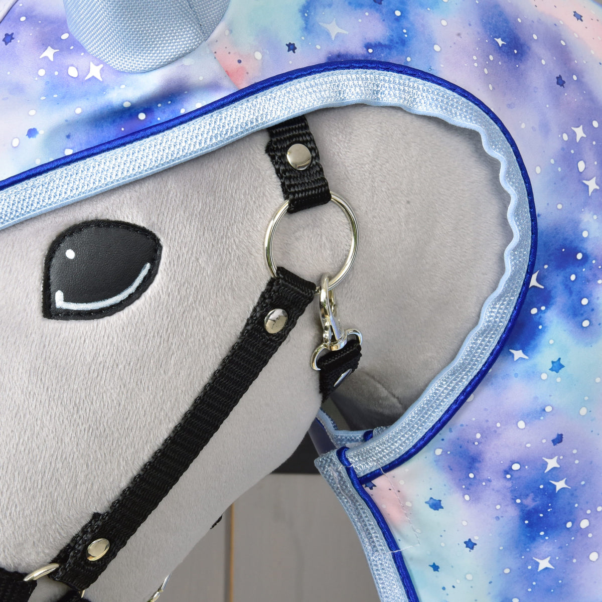 Close-up of the Raincoat Space hood edge with light blue binding and blue piping beside the black halter and eye