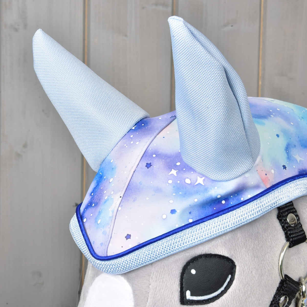 Close-up of the light blue fabric ears on the Raincoat Space hood, with white stars on the galaxy print and blue piping