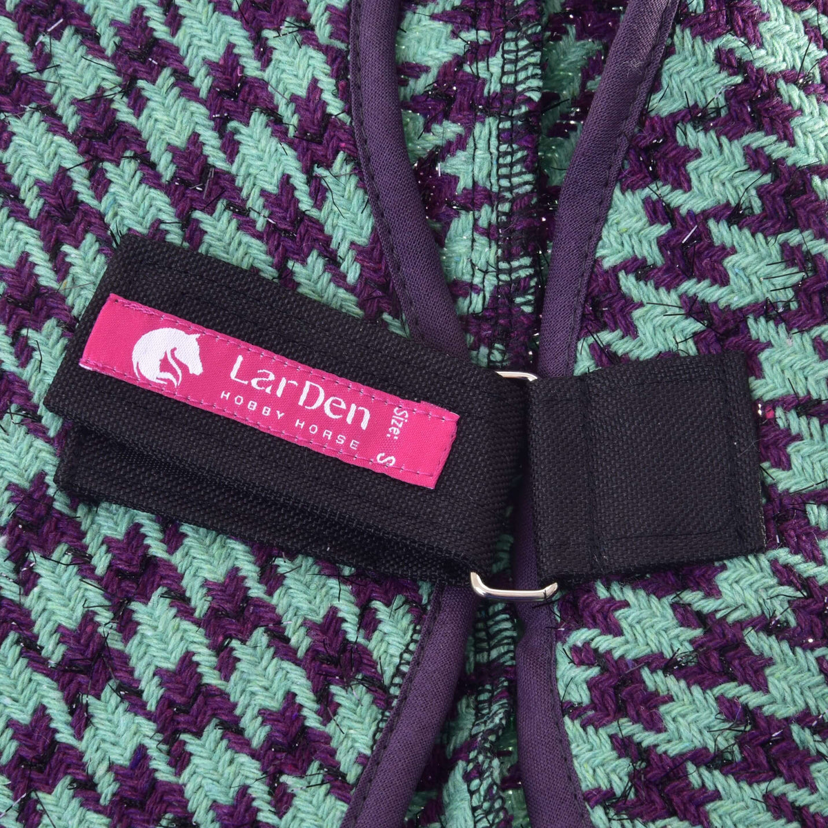 Gros plan sur l’étiquette rose LarDen de la sangle de poitrail de la couverture d’écurie Green pour Hobby Horse, tissage menthe et violet pailleté
