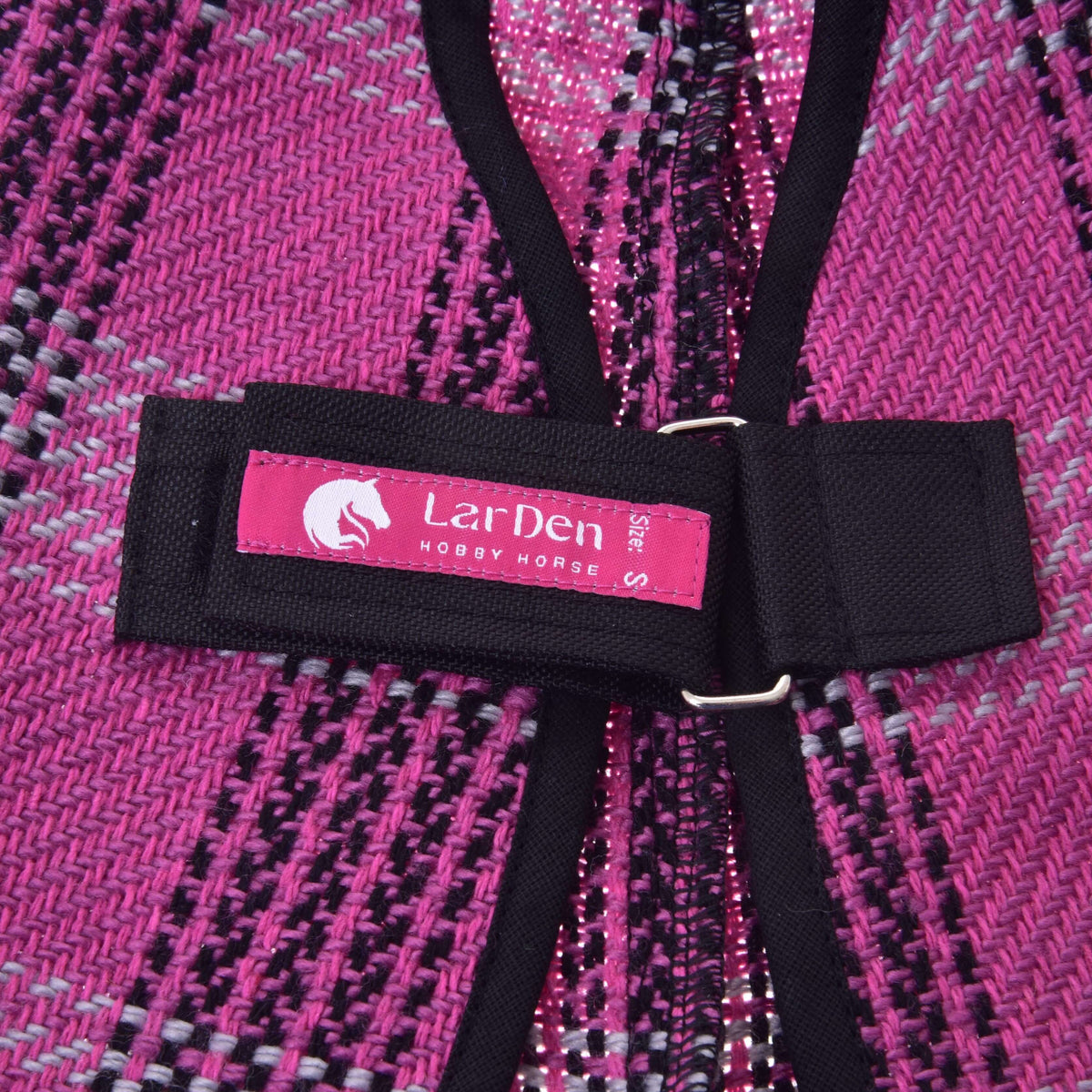 Gros plan sur l’étiquette rose LarDen de la sangle de poitrail noire de la couverture d’écurie Pink pour Hobby Horse, sur le tissage écossais