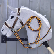 Lichtgrijze Hobby Horse in het bruine halster met beige bont, met gevlochten teugels en halstertouw in oranje en bruin
