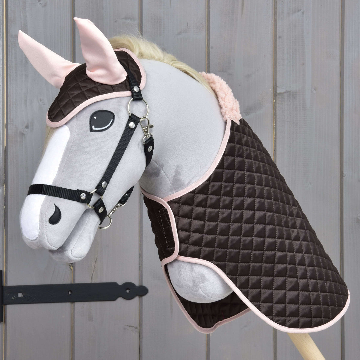 Hobby Horse gris au licol noir portant l’ensemble Thermo Sweety, couverture brune matelassée et bonnet d’oreilles aux oreilles roses